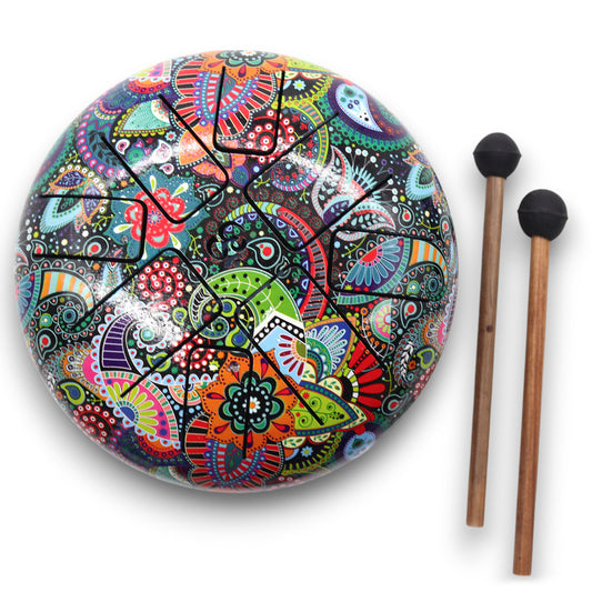 A colorful handpan drum, adorned with intricate floral and abstract patterns, rests beside two wooden mallets with black rubber tips on a white surface.