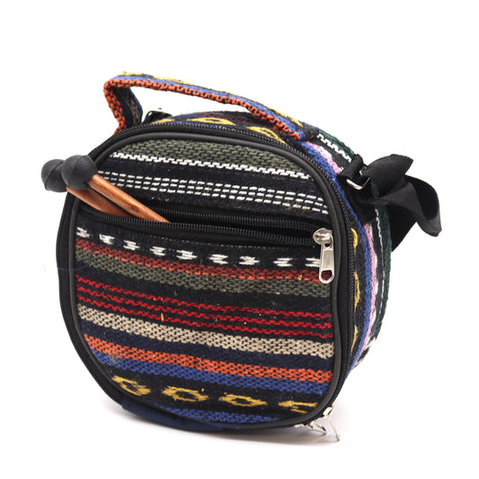 Round, colorful woven bag with a striped pattern and zippered pockets. It has a sturdy handle and a shoulder strap, set against a plain white background.