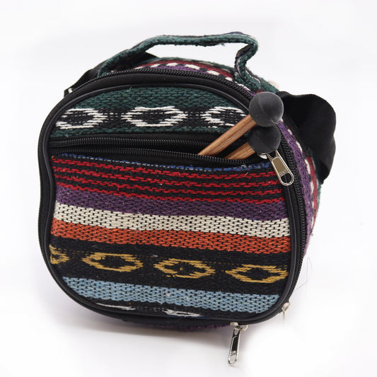 A small, colorful woven bag with horizontal stripes and a carry handle; wooden mallets with rubber ends protrude from a zippered front pocket. Text on zipper: "PALMS".