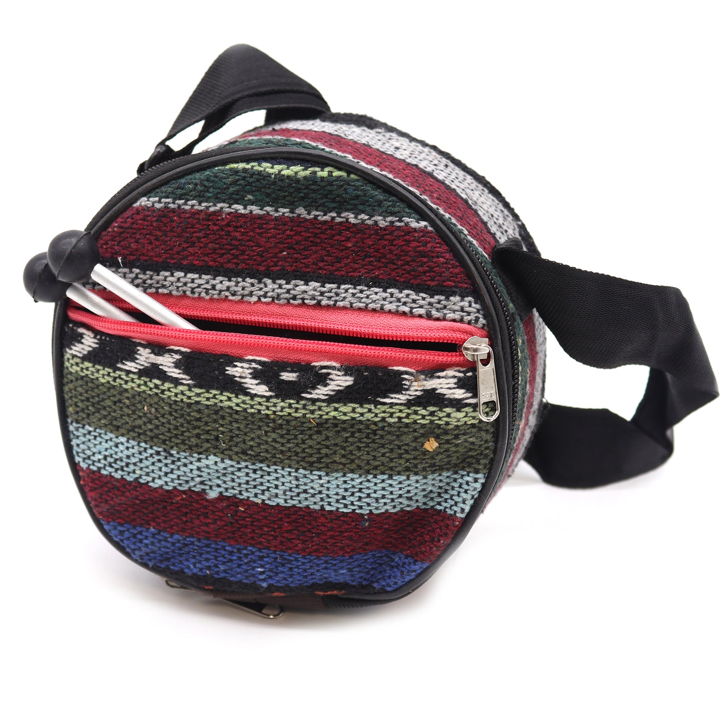 A round, multicolored knit-patterned bag with a red zipper contains two knitting needles, set against a plain white background. The bag features black straps for carrying.