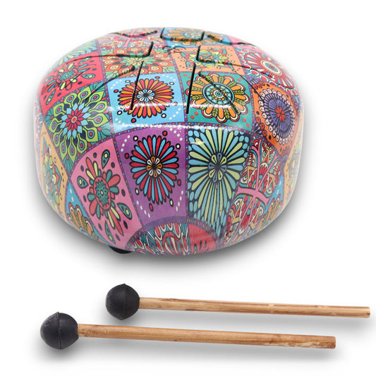 Colorful steel tongue drum with intricate floral patterns, resting on a surface. Two mallets with black rubber tips are placed nearby, ready for use.