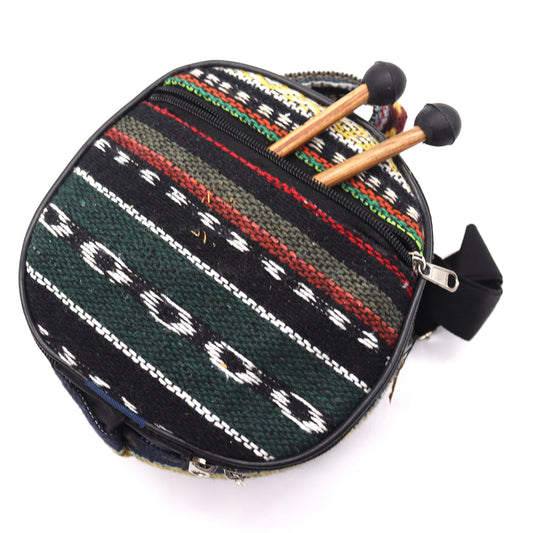 A round, woven bag with a colorful striped pattern is shown with a zipper. Two wooden mallets with black heads rest on top, suggesting a musical context.