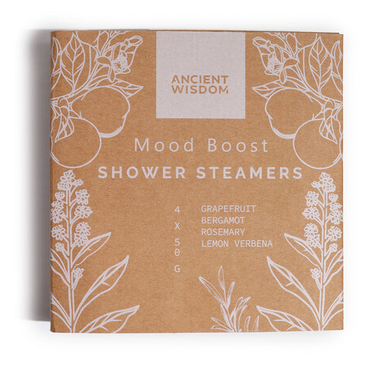 The square cardboard packaging features "Ancient Wisdom" and "Mood Boost Shower Steamers" text, decorated with white line drawings of citrus and botanical elements. Ingredients listed: grapefruit, bergamot, rosemary, lemon verbena, 4 x 50g.