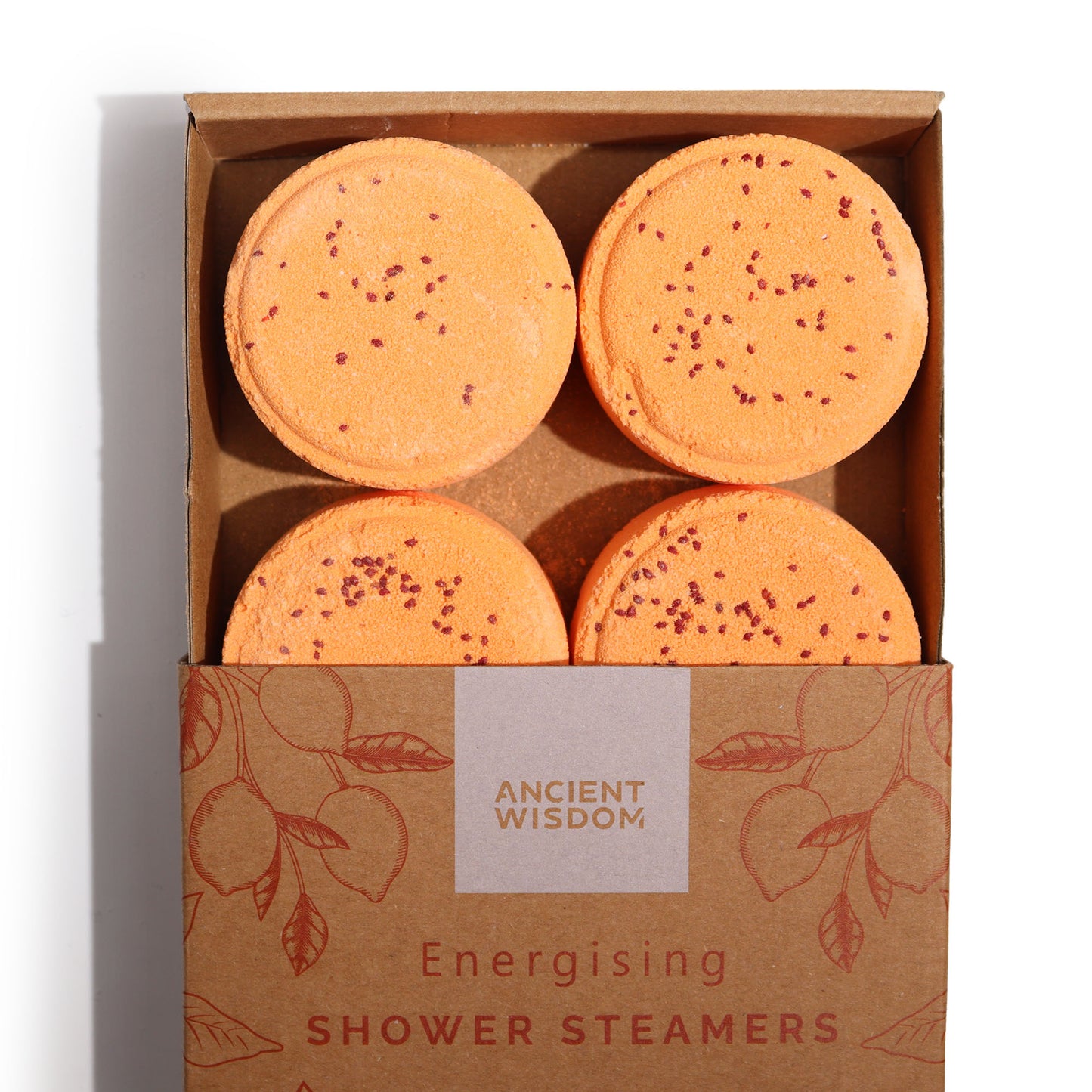Four orange shower steamers with red specks sit in an open cardboard box. The box features a floral design and text: "ANCIENT WISDOM Energising SHOWER STEAMERS."