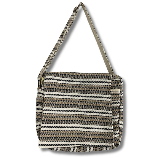A woven, striped shoulder bag hangs by its strap. The bag features alternating black, brown, and white horizontal patterns, creating a textured appearance against a plain white background.