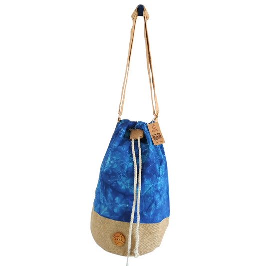 A blue tie-dye drawstring bag with a beige bottom and long brown straps hangs against a white background. A tag reads, "Byoom Jeol, 100% Eco-friendly."