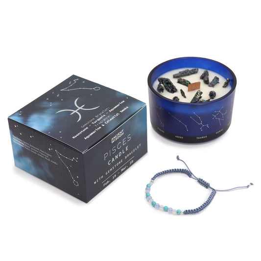 Box labeled "Pisces Candle with Gemstone Bracelet," alongside a blue candle adorned with constellation designs and crystals. A complementary braided bracelet, featuring small beads, rests nearby.
