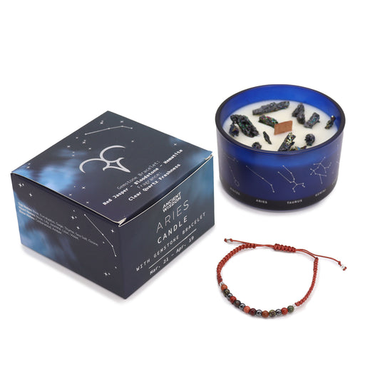 The candle features black crystals and a wooden wick. It's surrounded by a box with constellation designs, promoting an Aries candle and gemstone bracelet set. A beaded bracelet lies nearby. Text includes: "Ancient Wisdom, Aries Candle, with Gemstone Bracelet, Mar. 21 - Apr. 19."