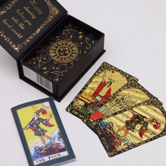 Tarot deck with golden cards featuring illustrations like "The Fool," displayed beside an open box with celestial designs and text: "Happy sharing takes you into the tarot world."