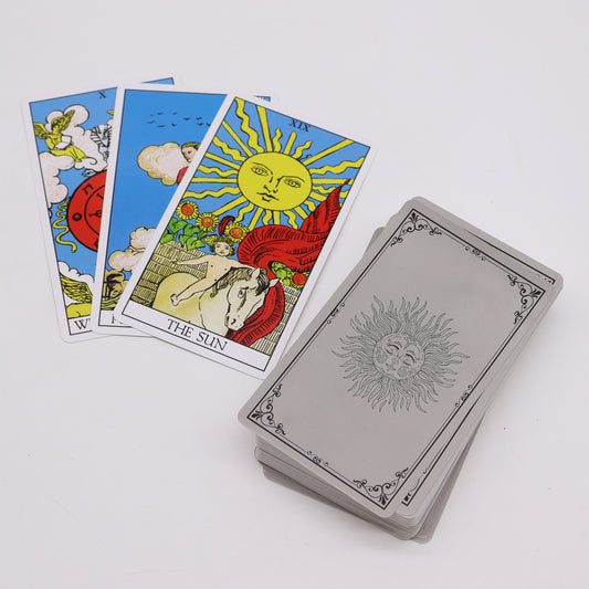 Three tarot cards are spread, featuring colorful illustrations with "THE SUN" card visible. A stacked deck rests nearby, designed with a sun motif on a plain surface.