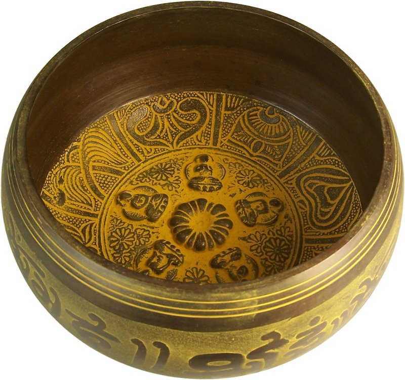 A brass bowl intricately engraved with detailed patterns and seated figures adorns its interior and exterior, set against a plain white background.