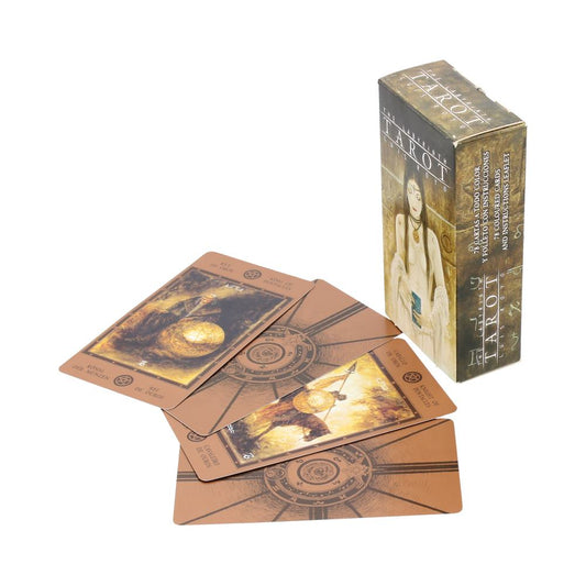 A fanned tarot deck lies face-up on a white surface while an illustrated tarot box stands upright nearby, Text: THE LABYRINTH TAROT; TAROT; 78 COLOURED CARDS AND INSTRUCTIONS LEAFLET; KING OF PENTACLES; REY DE OROS; KNIGHT OF PENTACLES; CABALLO DE OROS