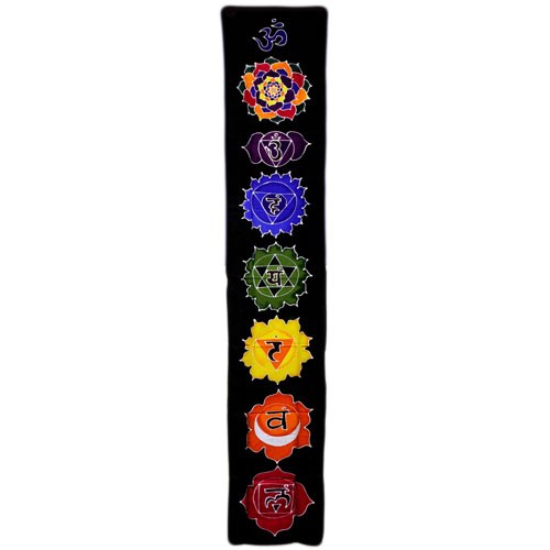 A black textile hangs vertically, displaying seven colorful chakra symbols, each with a Sanskrit seed syllable, arranged in a column.