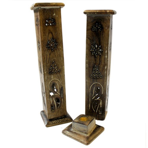 Wooden incense holders stand upright with intricate carvings of floral patterns. One is vertically positioned, while the other lies horizontally, showing a small circular area for incense placement.