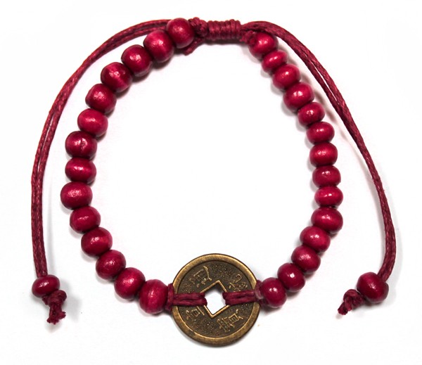 A red beaded bracelet is displayed against a white backdrop. A gold coin is tied onto the bracelet with red string, with what appears to be Chinese characters engraved.