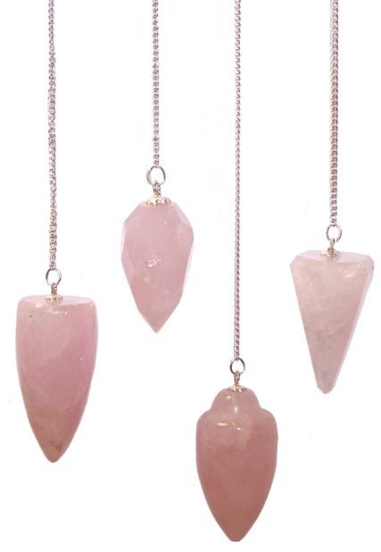 Four pink, polished pendulums hang vertically from silver chains. They are various shapes, suspended against a pure white backdrop.