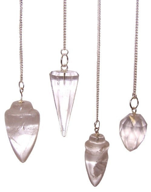 Four clear quartz pendulums, each a different shape, hang from silver chains. The objects are set against a stark white background.