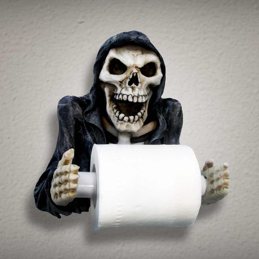 A grim reaper figurine holds a roll of toilet paper on a wall.