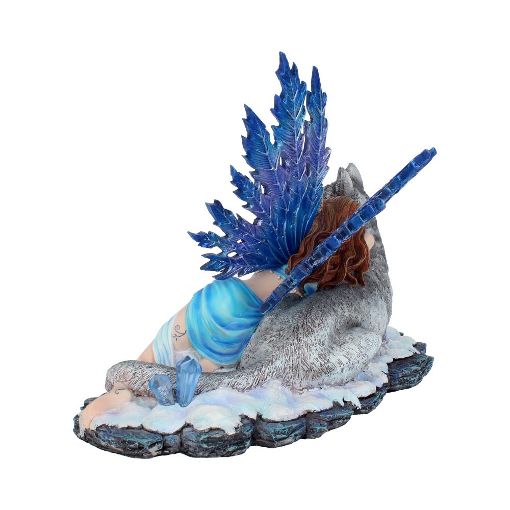A figurine of a fairy with blue wings reclines against a wolf, resting on a snowy, rocky base. The fairy wears a flowing blue dress, and the scene evokes a serene, mystical setting.