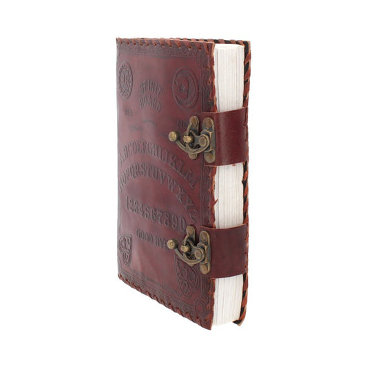 The closed, brown leather journal displays "SPIRIT BOARD," the alphabet, numbers, "YES," "NO," and "GOOD BYE" embossed on its cover. Two straps with metal clasps secure the journal. It sits against a white background.