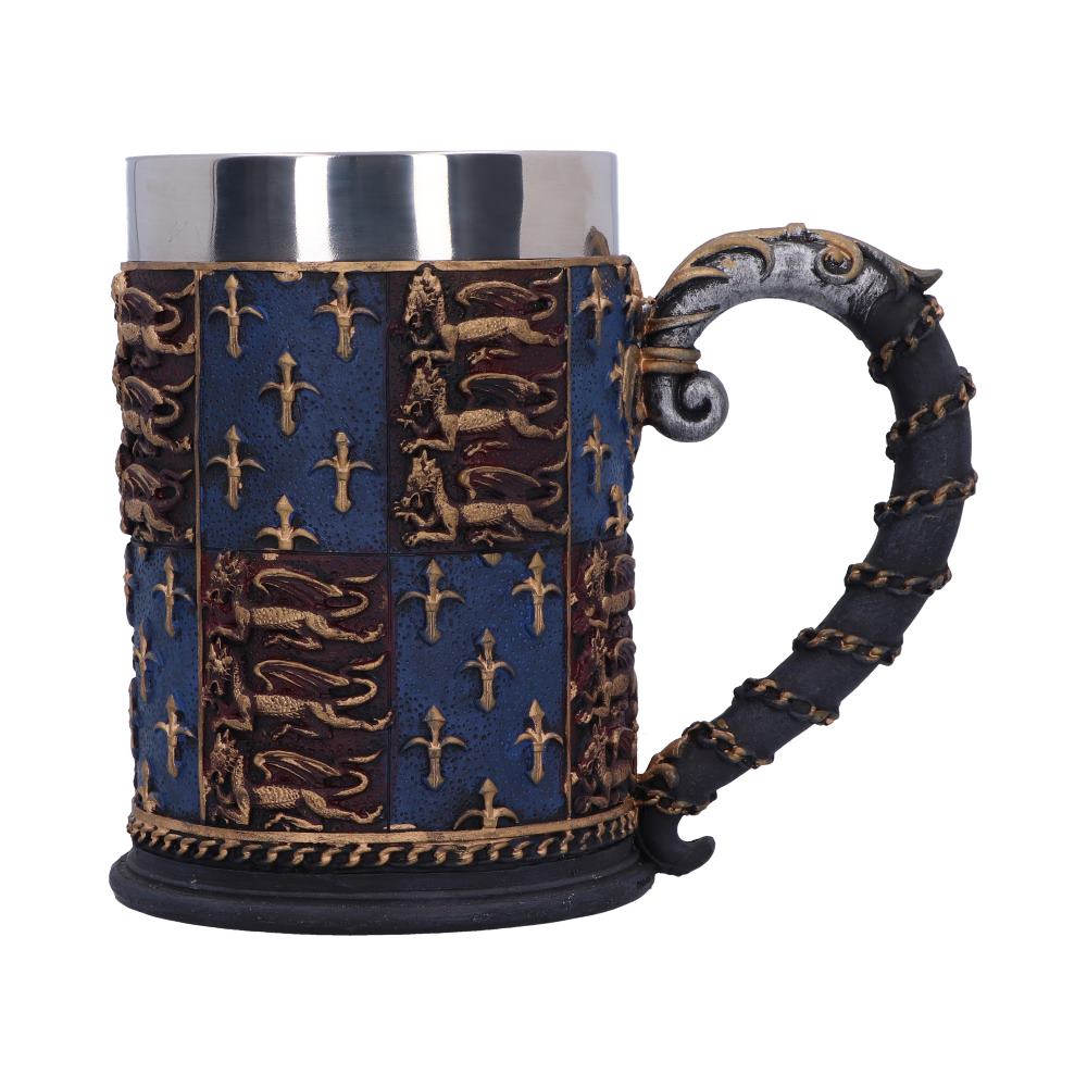 A decorative stein sits against a white backdrop, featuring a silver rim, coat-of-arms patterns, and a dark handle accented with gold rope wrapping.