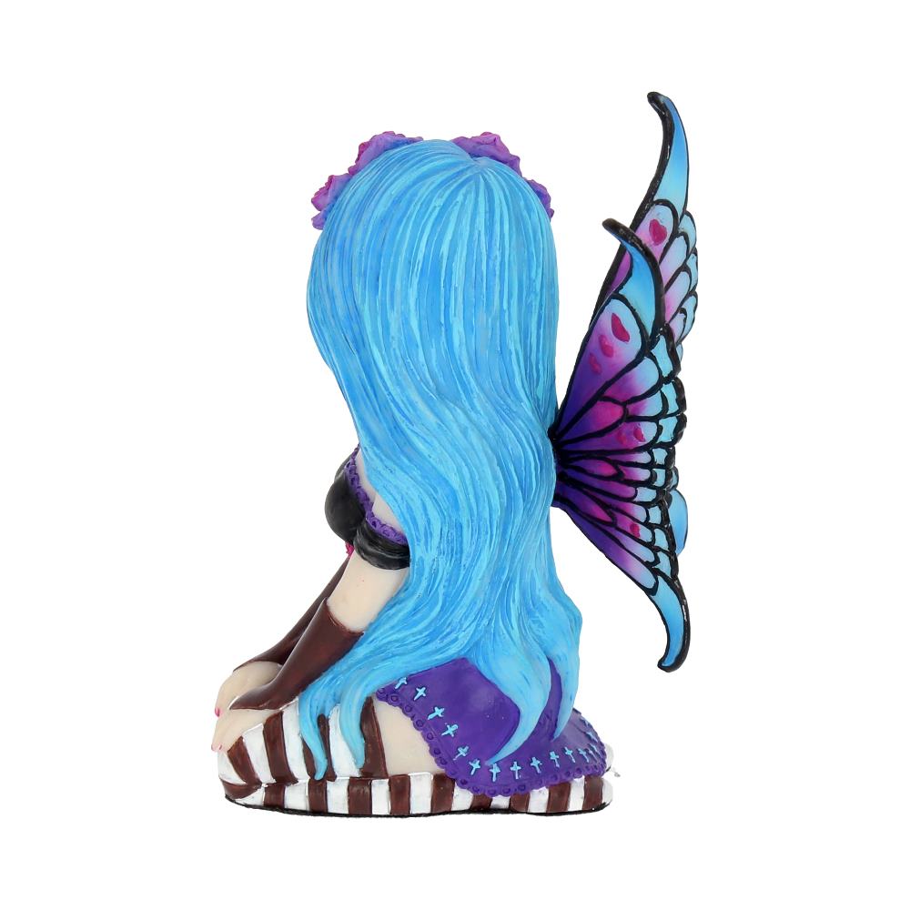 A figurine of a fairy with long blue hair, purple and blue wings sits with crossed legs, wearing a purple dress and brown boots, against a plain white background.
