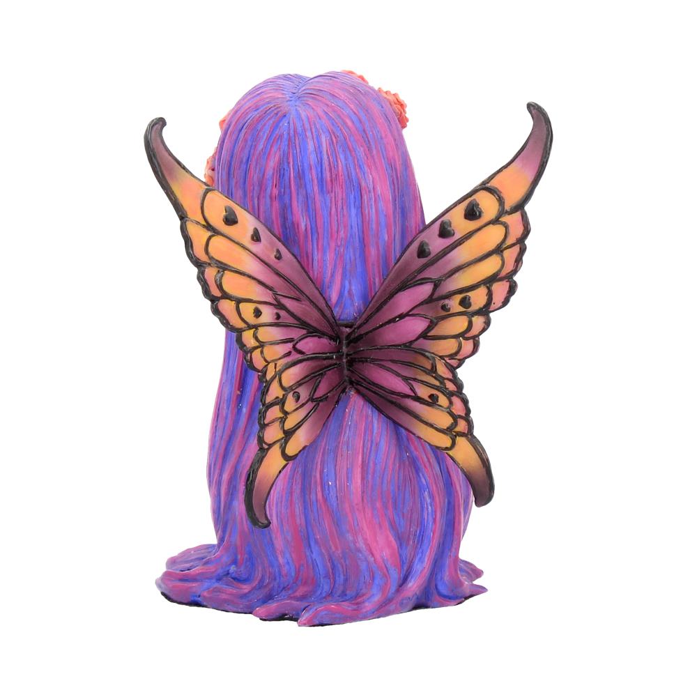 A colorful fairy figurine features large, vibrant butterfly wings attached to her back. The fairy's long, flowing purple hair cascades down, creating a whimsical appearance against a plain white backdrop.