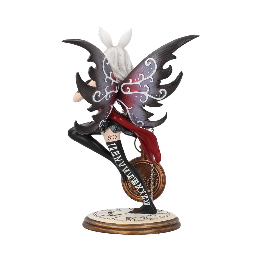 Figurine of a winged character crouching over a clock face, holding gears. The black wings have intricate designs. Black stockings display Roman numerals. The base features a clock with Roman numerals.