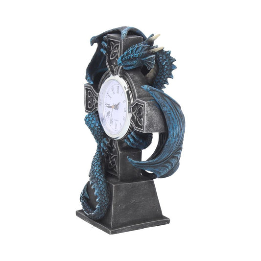 A clock, shaped like a Celtic cross, is adorned by a blue dragon. The dragon is wrapped around the cross. The clock stands on a gray base.