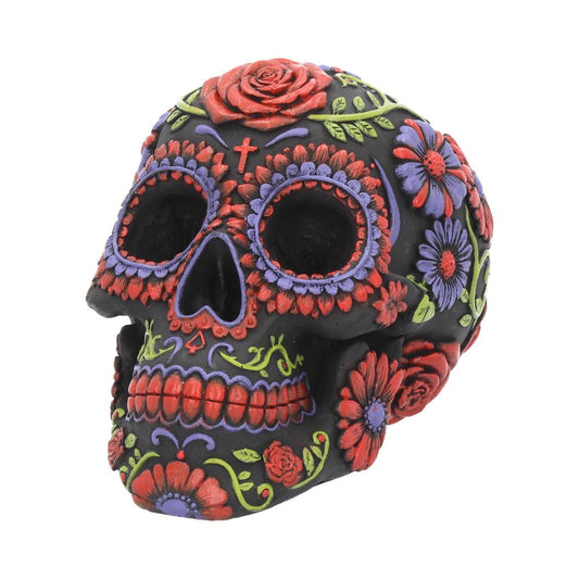 A black decorative skull adorned with colorful floral patterns and designs, including red and purple flowers and green leaves, set against a plain white background.