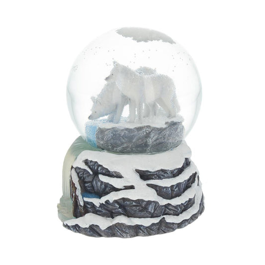 A snow globe features two white wolves standing on a rocky, snowy landscape. The globe rests on a textured base resembling snow-covered cliffs.