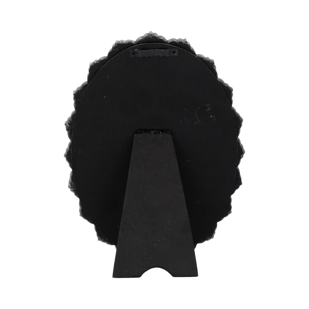 A circular, ornate picture frame stands on a small, black easel. The frame is black with a textured, decorative edge. The background is white.