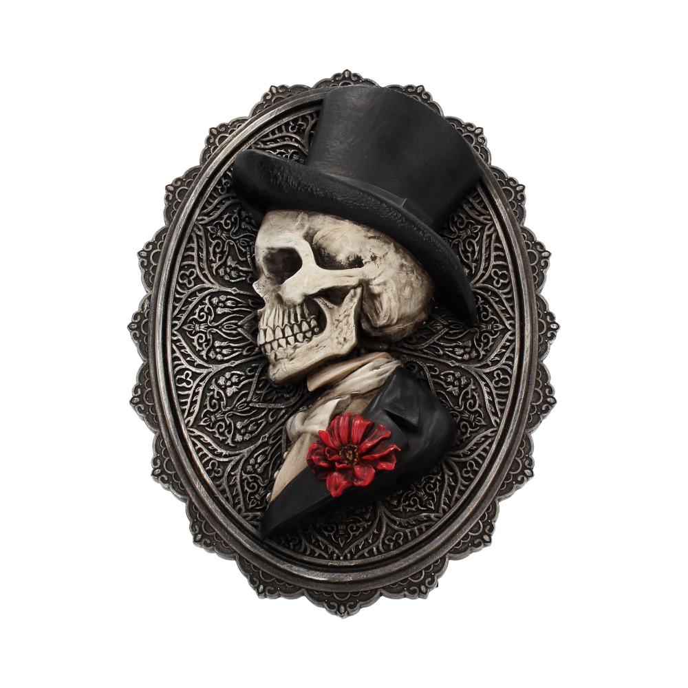 A skull wearing a top hat and tuxedo is depicted in profile within an ornate oval frame.