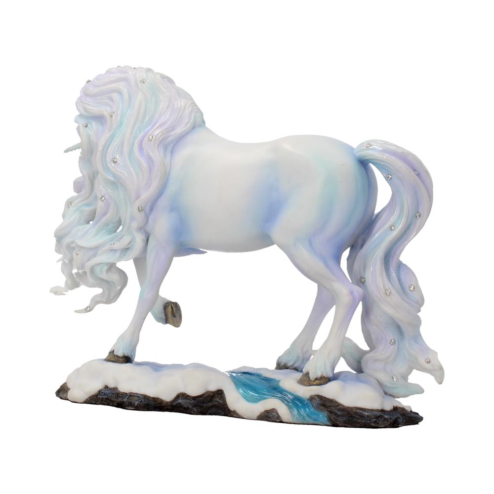 A unicorn figurine, shaded white and blue, stands on a snowy, rocky base next to a small blue stream. Its long mane and tail are decorated with small jewels.