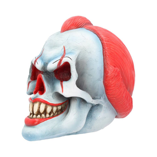 A skull with clown features, exhibiting red eyes, mouth, and exaggerated teeth, is adorned with bright red hair, set against a plain white background.