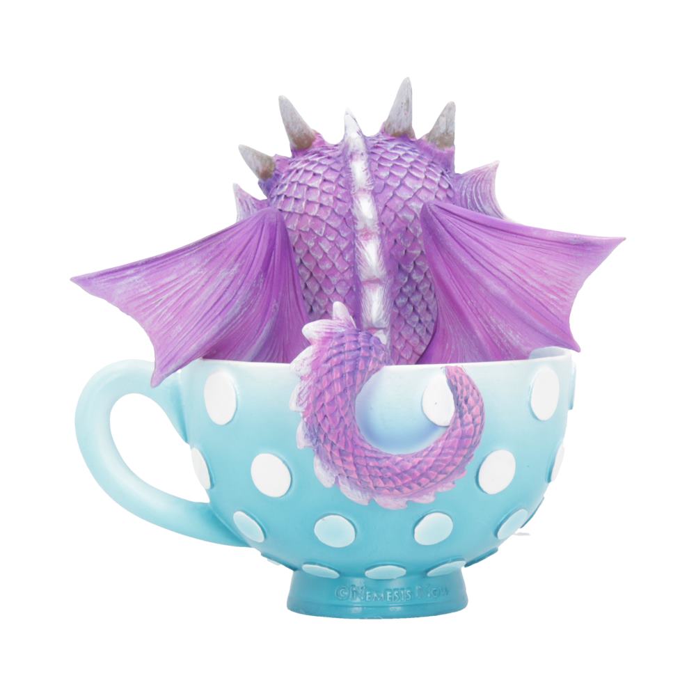 A purple dragon with wings and a tail sits inside a light blue, polka-dotted teacup. Text: ©NEMESIS NOW.