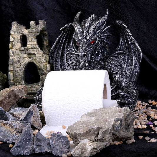 A dragon statue holds a roll of toilet paper, amidst rocks and a miniature ruined castle.