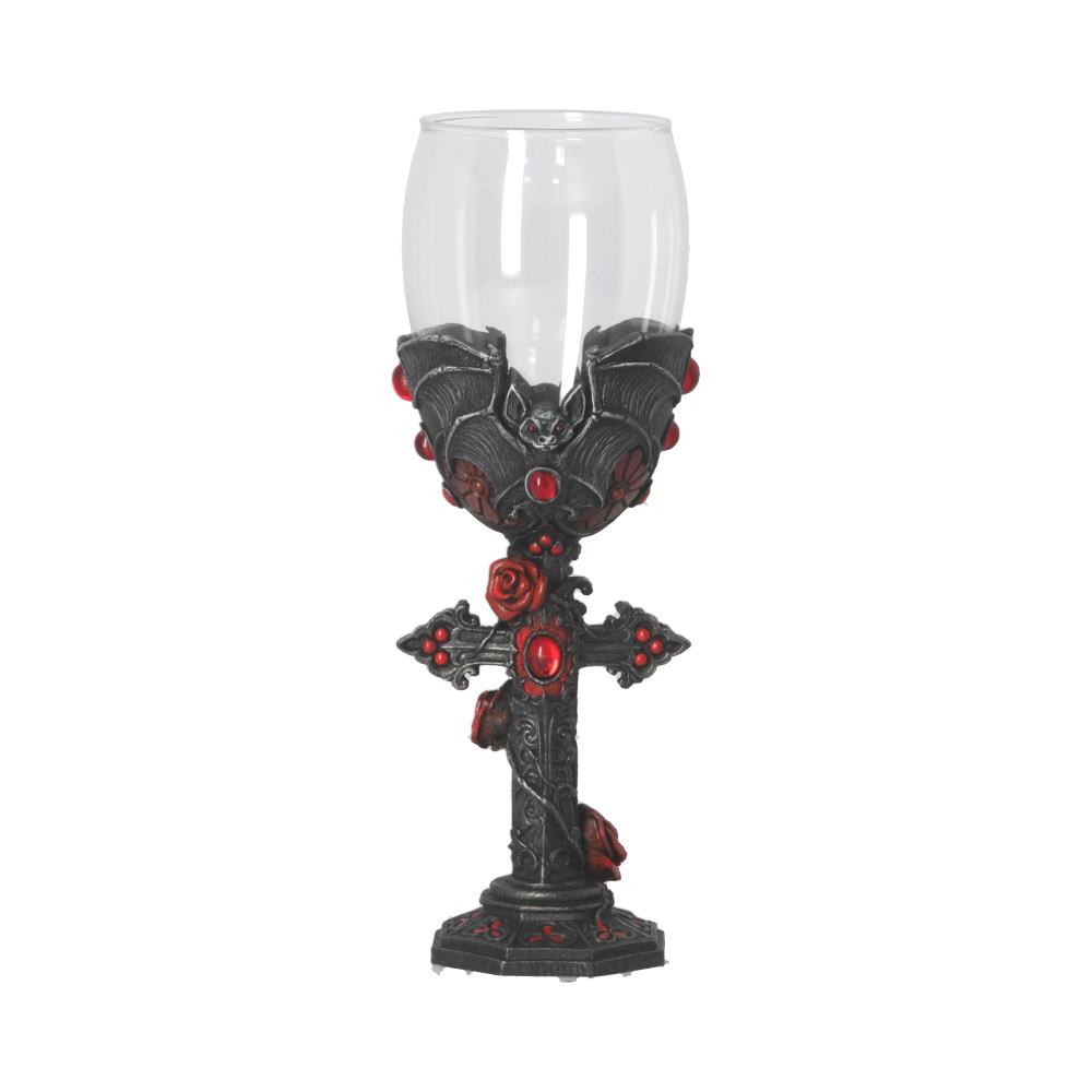 A clear wine glass sits atop an ornate black stem decorated with a cross, roses, bats, and red gems, all against a bright white backdrop.