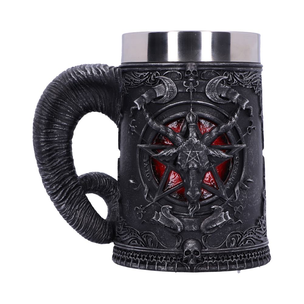 A dark, ornate mug with a silver top has a large, curved ram's horn as a handle. A red pentagram containing a goat’s head decorates the front with text reading “SOLVE” and “COAGULA”.