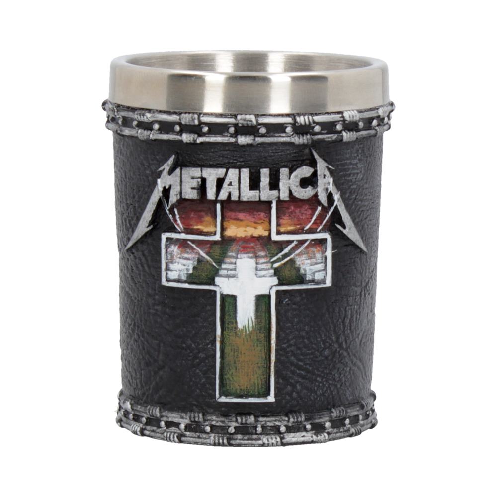 A metal and leather shot glass displays the word "METALLICA" above a cross design with a sunset background. The leather features a stitched pattern, creating a rugged, decorative appearance.