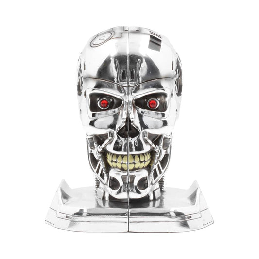 A metallic, robotic skull with glowing red eyes and exposed teeth sits upright. It's highly detailed and reflective, positioned on a smooth base, resembling a futuristic or sci-fi design.