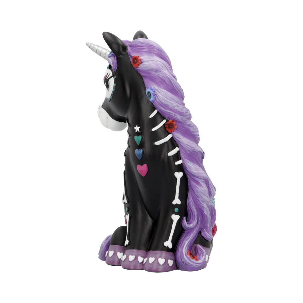 A black, seated unicorn statuette has a purple mane and Day-of-the-Dead style paint, featuring bones, stars, hearts and flowers, against an isolated white background.