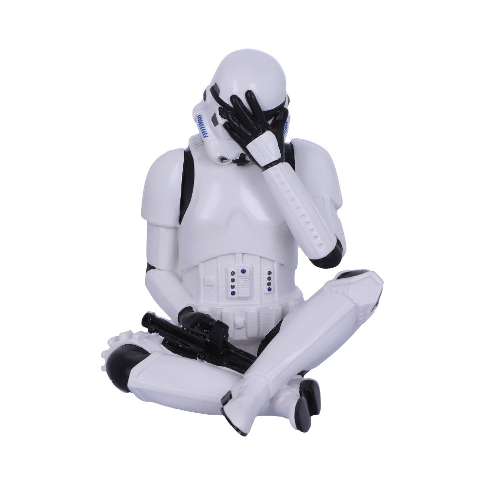 A stormtrooper figurine sits cross-legged, facepalming with one hand, while holding a blaster with the other, surrounded by a plain white background.