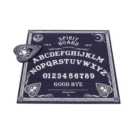 A dark-themed spirit board displays letters, numbers, "YES," "NO," and "GOOD BYE" with ornate designs, a skull-decorated planchette, and text: "SPIRIT BOARD USE WITH CAUTION." Company mention: "NEMESIS NOW."