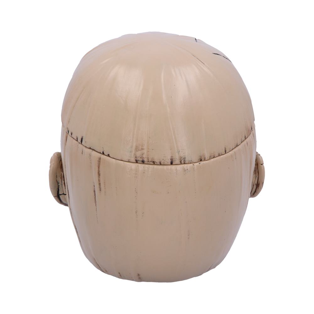 A beige head sculpture with simple features and visible lines stands against a plain white background, resembling a stylized character.