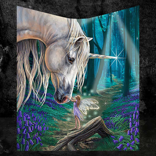 A white unicorn gently touches noses with a fairy standing on a log in an enchanted forest filled with purple flowers.