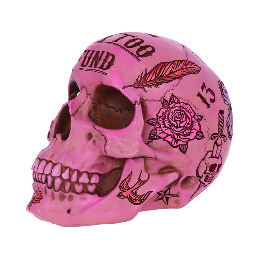 A pink skull is decorated with black tattoos, including feathers, roses, birds, a skull with a top hat, a dagger, and the words "TOO TATTOOED TO BE" and "BOUND," set against a white background.