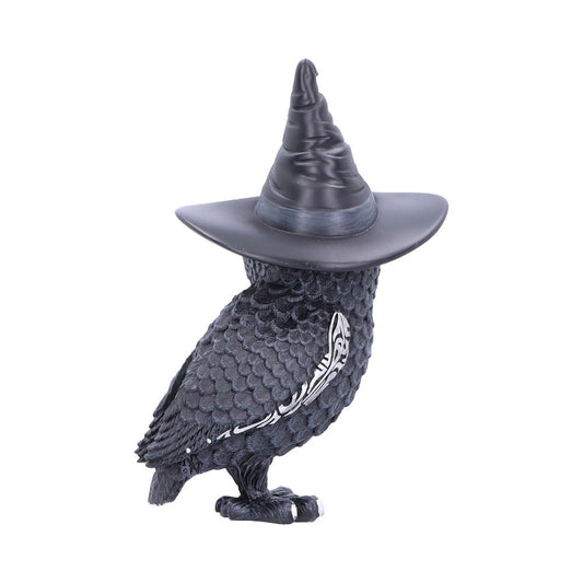 A black owl figurine wears a tall, pointed witch hat, standing against a plain white background. Its textured feathers have a subtle sheen, with intricate detailing along the wing.