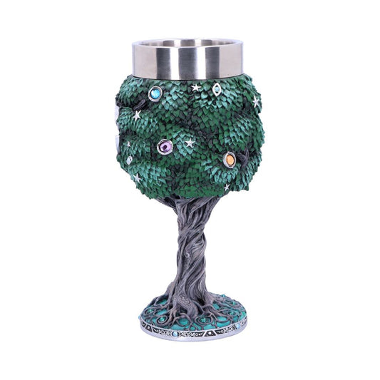 A decorative goblet shaped like a tree, with green leaves, jewel-like embellishments, and stars forms the cup, atop a twisted, rooted base against a white backdrop.