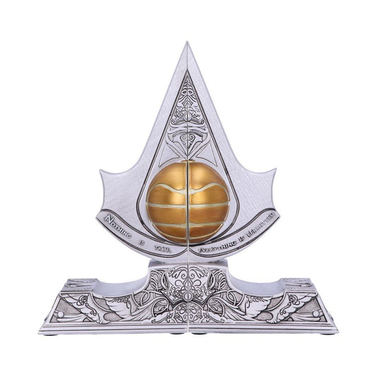 A silver emblem with a pointed top features a gold sphere at the center. Intricate designs adorn its surface. Below, text reads: "NOTHING IS TRUE. EVERYTHING IS PERMITTED."